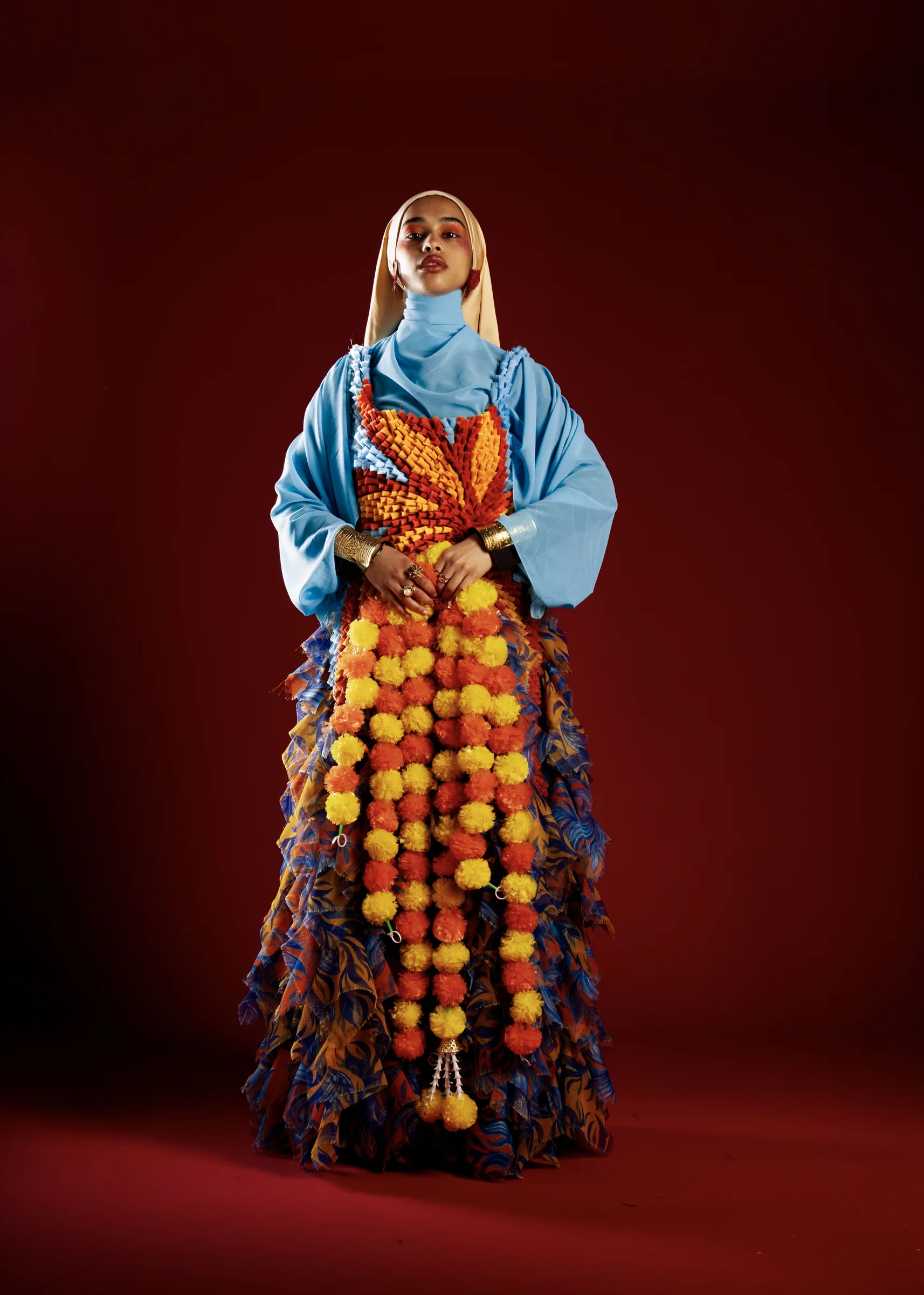 Seated portrait — marigold strands across the lap